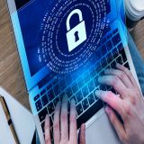 Cyberkriminalität wird symbolisch auf einem Laptop angezeigt.