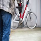 Mann mit Bolzenschneider nähert sich Fahrrad