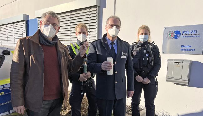 Polizeiseelsorger Norbert Schmitz übergibt in Waldbröl das Friedenslicht an Wachleiter Ernst Seeberger.