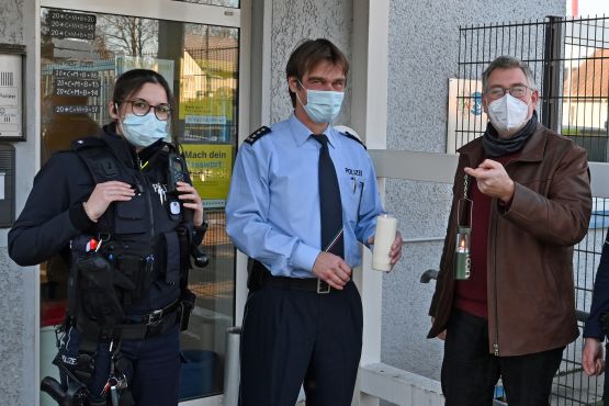 Polizeiseelsorger Norbert Schmitz übergibt das Friedenslicht in Wipperfürth an Wachleiter Uwe Elias.