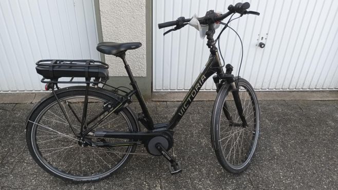 Schwarzes E-Bike mit tieferem Einstieg. Auf dem Rahmen ist die Victoria eingedruckt